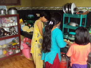 Children are happily learning the cooking skills.