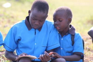 Two young students read a book provided by RtL