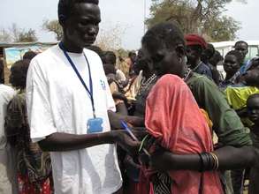 Staff screen a displaced child for malnutrition