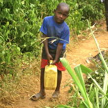 A Young Boy Carrying a Jerry Can