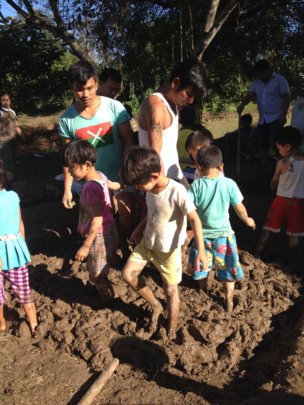 Kachin children in making mud bricks for school