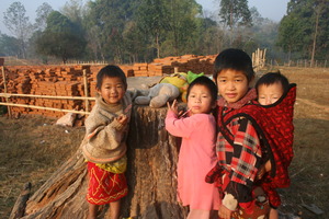 Kachin children playing near finished bricks