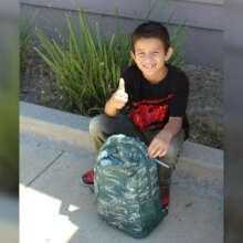 A recipient smiling with their backpack