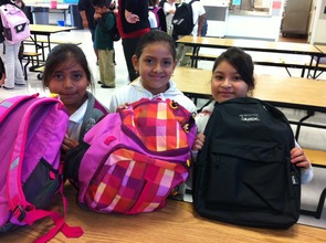 A trio of smiles and backpacks