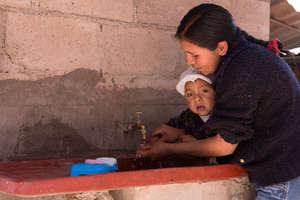 a mother washing hands with her child
