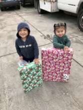 Two children smiling with their gifts!