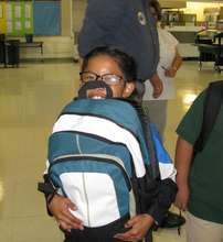 A little boy hugs his new backpack