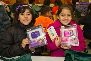 Two girls proudly show off their digital cameras