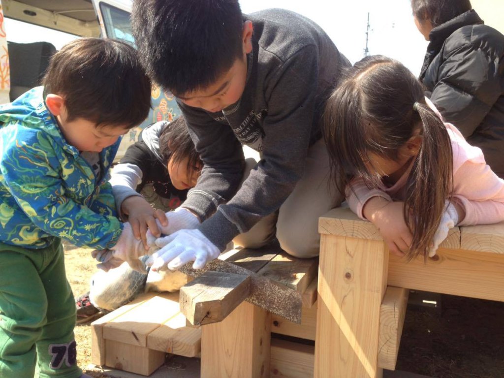An older child told the younger how to use a saw
