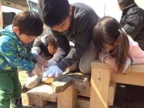 An older child told the younger how to use a saw