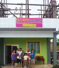 Nerissa's family in front of rebuilt birth clinic