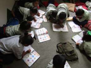 Jalpeshwori students writing in their workbooks