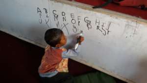 Young boy practices his writing