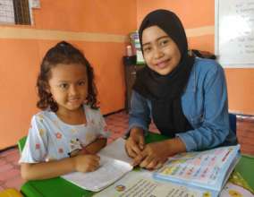 Fitriyah is giving tutorial to the younger student