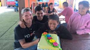 Wayne & Gabriel bring a birthday cake to Kevin.