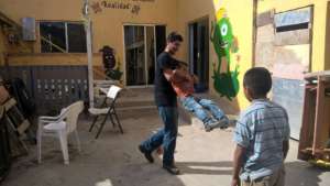 Gabriel swinging the boys at the orphanage.