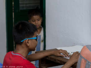 Looking at big brother doing his Braille homework