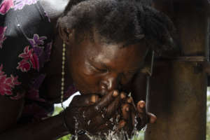 Elizabeth enjoys a drink from the village well.