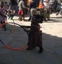 A little girl learning to hula hoop