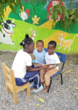 Older student reading to preschool students