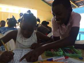 Kendi uses Creole to help his classmate, Yudelca.