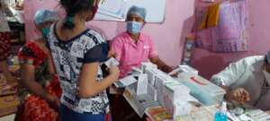 Medical team handing out medicines to a girl