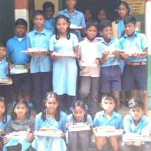 All smiles with the books and stationery kit.
