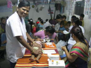 Nirmala assisting a baby's check up
