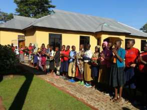 Resident girls sing a welcome