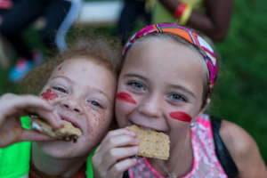 Torey, left, eats a s'more with a friend at Camp