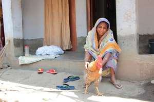 Shivia poultry farmer with one of her hens