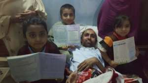 Muhammed and his children holding up their grades