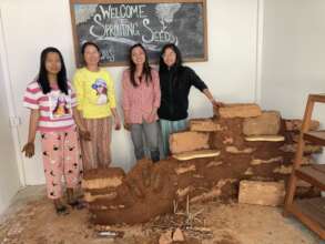 Teacher interns building earthen counter at cafe