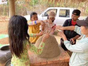 Interns building their first mud brick bread oven