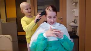 Meja cutting hair to her hospital ward friend