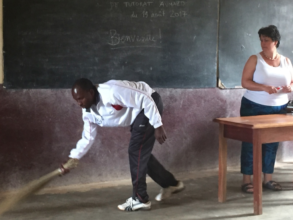 A teacher unusually sweeping the classroom floor