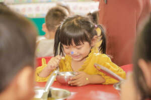 Student enjoying lunch at Peacetrees Kindergarten