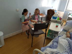 Young girls playing the ukulele for patients