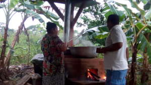 SHI staff and beneficiary try out new stove