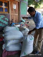 Margarito opening a bag of fertilizer.