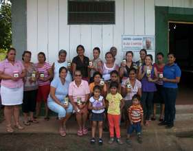 Beneficiaries display their first jars of pickles.