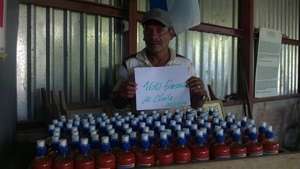 Teofilo displays bottles of his sauce