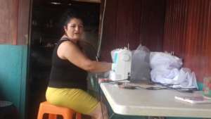 Sita sewing a wedding dress in her small shop
