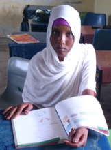 Fatuma with textbook provided by the foundation