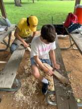 Shaving down hickory sapling into a bow