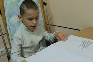 A blind boy is studying the book