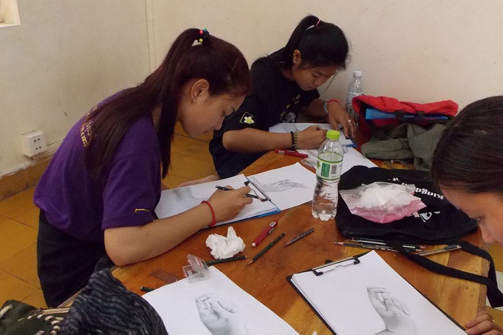 Students practicing drawing a dancer's hand