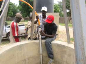 CREATE! technicians install the solar-powered pump