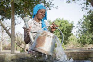 Woman filling up her watering can from the basin