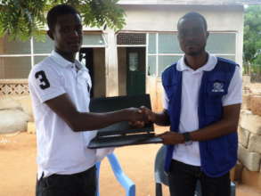 James receiving a laptop from IOM staff